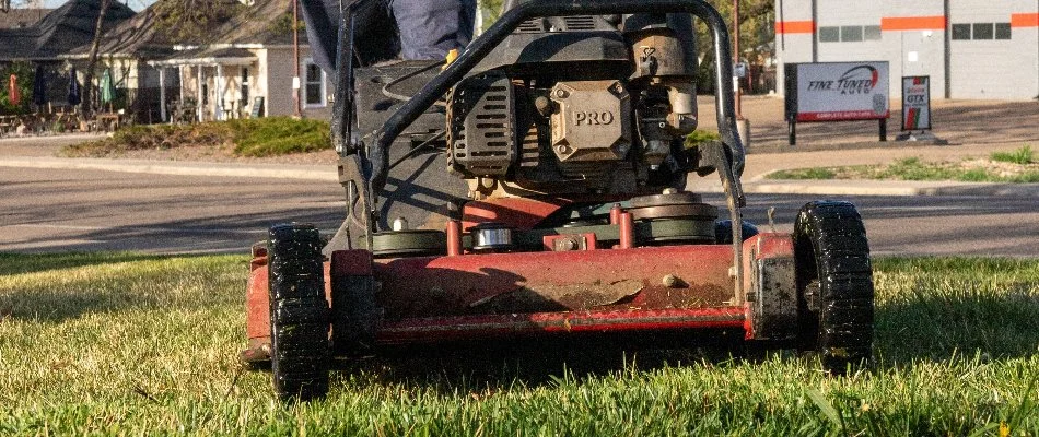 Grass being mowed by a red mower in Longmont, CO.