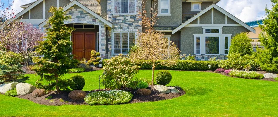 Large house in Longmont, CO, with a lawn and landscape beds.