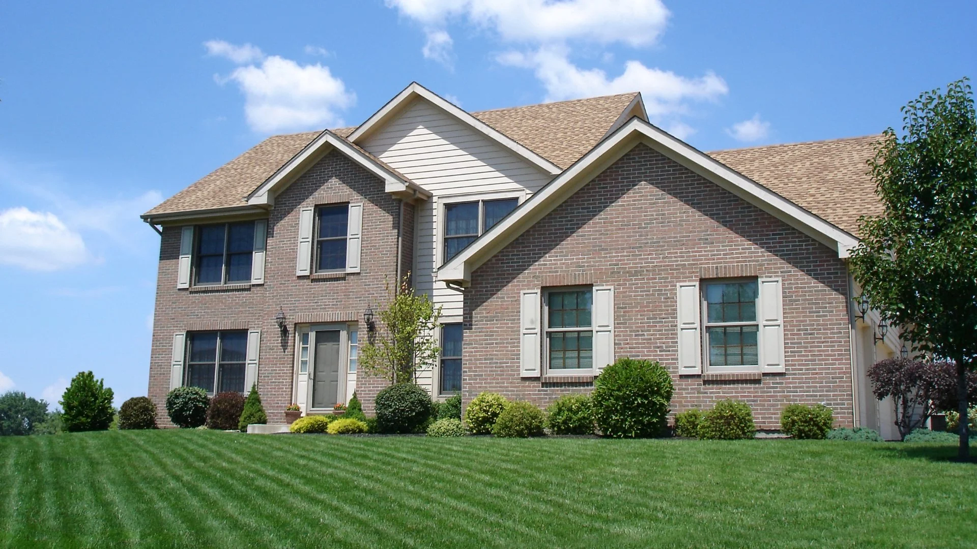 Brick house on a mowed green lawn.